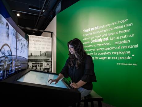 Woman looking at green book traveling exhibition 