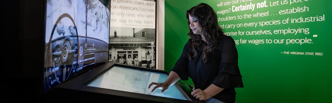 Woman looking at green book traveling exhibition 